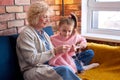 side view on happy caucasian family knitting. Senior woman and child girl at home