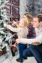 Side view of happy family decorating Christmas tree at home. Con Royalty Free Stock Photo