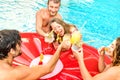 Side view of happy friends drinking fruit cocktails at swimming pool party - Vacation concept with guys and girls having fun in