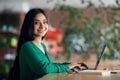 Side view of happy indian lady freelancer working from cafe Royalty Free Stock Photo