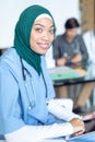 Happy female surgeon in hijab looking at camera while using digital tablet in the hospital Royalty Free Stock Photo