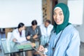 Happy female surgeon in hijab looking at camera while using digital tablet in the hospital Royalty Free Stock Photo