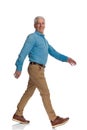 Side view of happy old man with sneakers smiling and walking Royalty Free Stock Photo