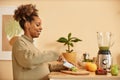 Cheerful Expectant Mother Cutting Fruits in Kitchen Royalty Free Stock Photo