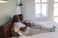 Senior couple using digital tablet while enjoying a cup of coffee in bedroom Royalty Free Stock Photo