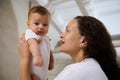 Side view of a happy smiling woman mother holding her baby boy in her arms. Close-up portrait Royalty Free Stock Photo