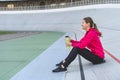 Young adult athlete woman resting after training in city