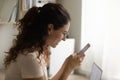 Happy smiling young lady holding mobile phone reading good news Royalty Free Stock Photo