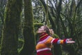 Side view of happy tourist enjoying green forest woods and trees opening arms and outstretching with smile expression and serene Royalty Free Stock Photo