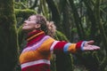 Side view of happy tourist enjoying green forest woods and trees opening arms and outstretching with smile expression and serene Royalty Free Stock Photo