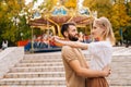 Side view of happy young couple in love standing embracing smiling looking at each other in amusement park in summer day Royalty Free Stock Photo