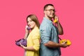 side view of happy young couple standing back to back and talking by rotary phones isolated