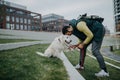 Side view of happy young man training his dog outdoors in city. Royalty Free Stock Photo