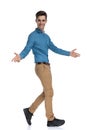 Side view of happy young man walking and opening arms Royalty Free Stock Photo