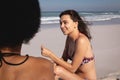 Young women interacting with each other on the beach Royalty Free Stock Photo