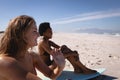 Happy young women sitting on surfboard at beach in the sunshine Royalty Free Stock Photo