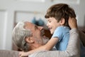 Overjoyed older mature granddad embracing little grandson.