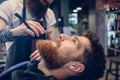 Bearded young man ready for shaving in the hair salon of a skill Royalty Free Stock Photo