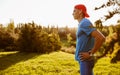 Side view of healthy sporty male athlete standing with his hands on waist looking aside on sunlight sunet in the park. Fit runner Royalty Free Stock Photo