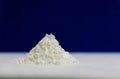 Side view of heap of white modified starch isolated on blue and gray background