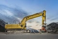 Side view of a heavy yellow grab excavator with grapple