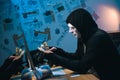 side view of hooded hacker in mask counting stolen money Royalty Free Stock Photo
