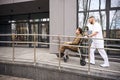 Healthcare worker transporting serviceperson with disability to private clinic Royalty Free Stock Photo