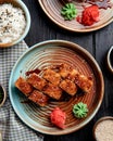 side view of hot fried sushi rolls with salmon avocado and cheese served with ginger and wasabi on a plate on wooden background Royalty Free Stock Photo