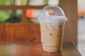 Side view Ice coffee cappuccino, latte, mocha in plastic cup with water drop on wooden column with blurry garden background with Royalty Free Stock Photo