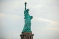 Side view of the iconic Statue of Liberty standing against a cloudy sky