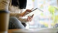 Side view image of an Asian female graphic designer using her digital tablet at the coffee shop Royalty Free Stock Photo