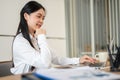 A beautiful Asian businesswoman or female office employee is working on her laptop at her desk Royalty Free Stock Photo