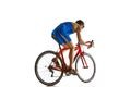 Side view image of concentrated sportsman in blue sportswear and helmet in motion on bike isolated on white studio Royalty Free Stock Photo