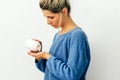 Side view image of woman`s hand pours the pills out of the bottle. Young blonde female wearing blue knitted sweater pouring some Royalty Free Stock Photo