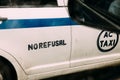 Side view of Indian white taxi with blue stripe on the road with words `No Refusal` in Kolkata, India