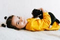Side view indoor image of a smiling happy child playing at home with a little dog. Pretty little girl cares about the puppy. Royalty Free Stock Photo