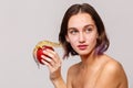 Side view. Isolation. Attractive girl holding in hand a red apple on which sits an iguana gecko. Royalty Free Stock Photo