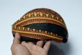 side view of a Javanese headgear (blangkon) in the hands of an Asian man,