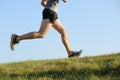 Side view of a jogger legs running on the grass Royalty Free Stock Photo