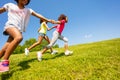 Side view of kids running on the grass park field Royalty Free Stock Photo