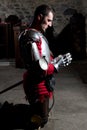 Side View of Knight Kneeling on His Knees With His Head Bowed and Hands in Prayer in the Old Church Before the Battle Royalty Free Stock Photo