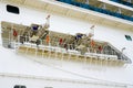 Side view of a large cruise ship with many hanging life rafts, emergency self inflating rescue rafts