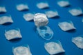 Side view of a layout of disposable contact lenses in containers lying with an open single lens container on a blue Royalty Free Stock Photo