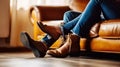 Side view of legs in leather boots of faceless people resting on sofa in living room, Generative AI