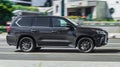 Side view of Lexus LX 570 Third generation J200 suv in motion. Black big 4x4 car moving on the street