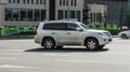 Side view of Lexus LX 570 Third generation J200 suv in motion. White pre-facelift styling 4x4 car moving on the street