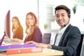 Side view of line of call centre employees are smiling and working on computers. Businesspeople In A Row Wearing Headset Working Royalty Free Stock Photo