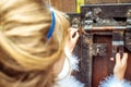 Side view of an little beautiful girl in the scenery of Alice in Wonderland looking into the keyhole of the gate Royalty Free Stock Photo