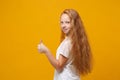 Side view of little ginger kid girl 12-13 years old in white t-shirt isolated on yellow wall background children studio Royalty Free Stock Photo