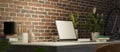 Side view, Loft apartment with brick wall, work station with laptop blank screen mockup Royalty Free Stock Photo